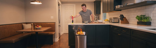 Person reaching out for their Element Fire Extinguisher as the garbage bin is on fire