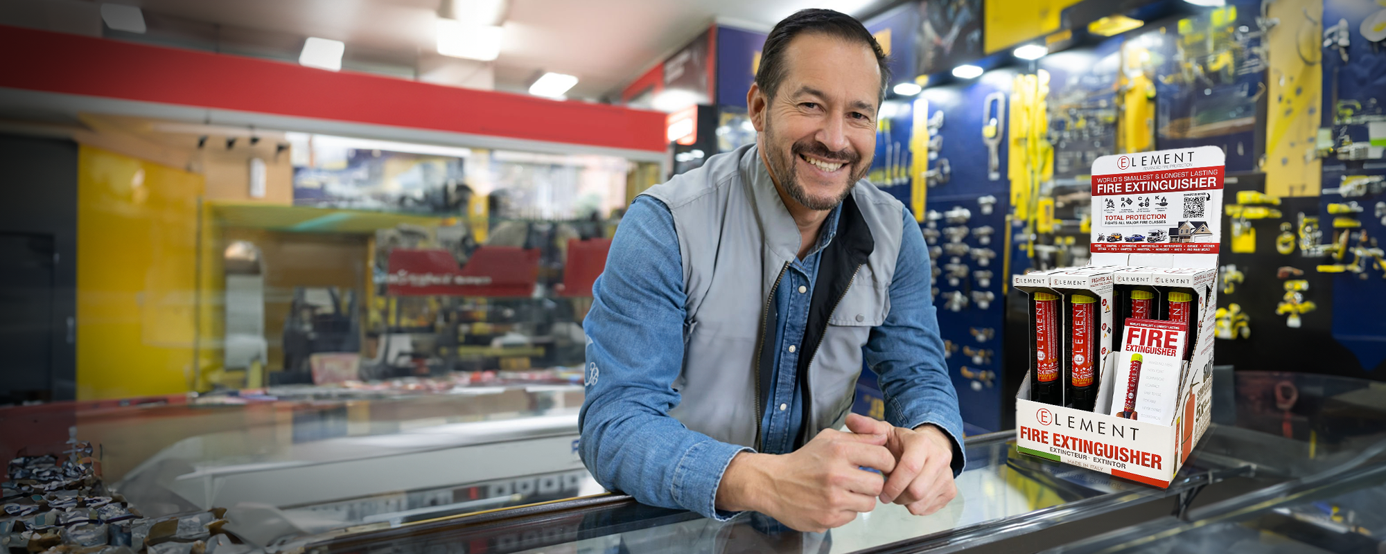 Hardware store owner with a Display of 10 Element Fire Extinguishers on the counter.